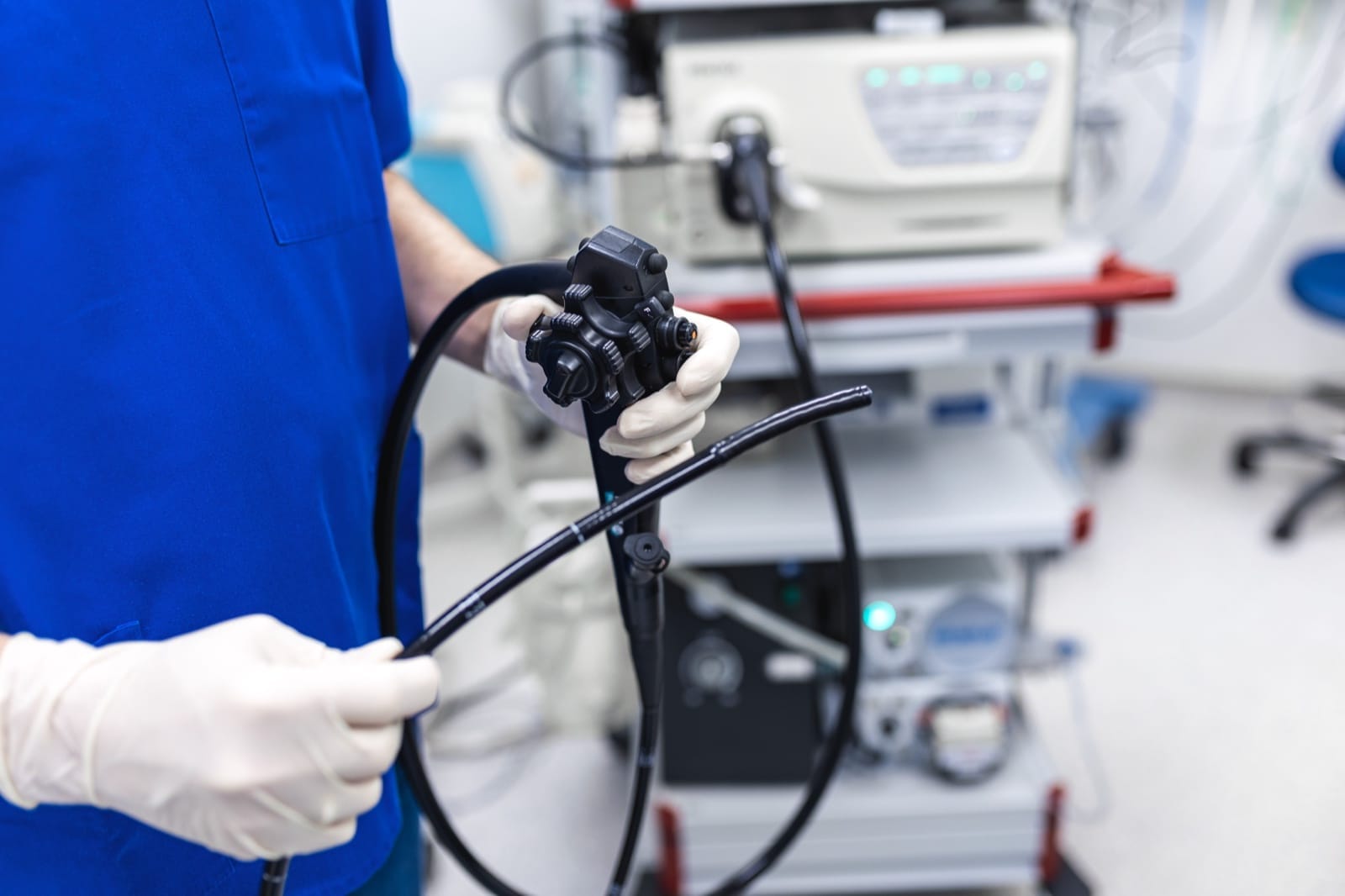 A clinician holding an endoscope in an endoscopy suite