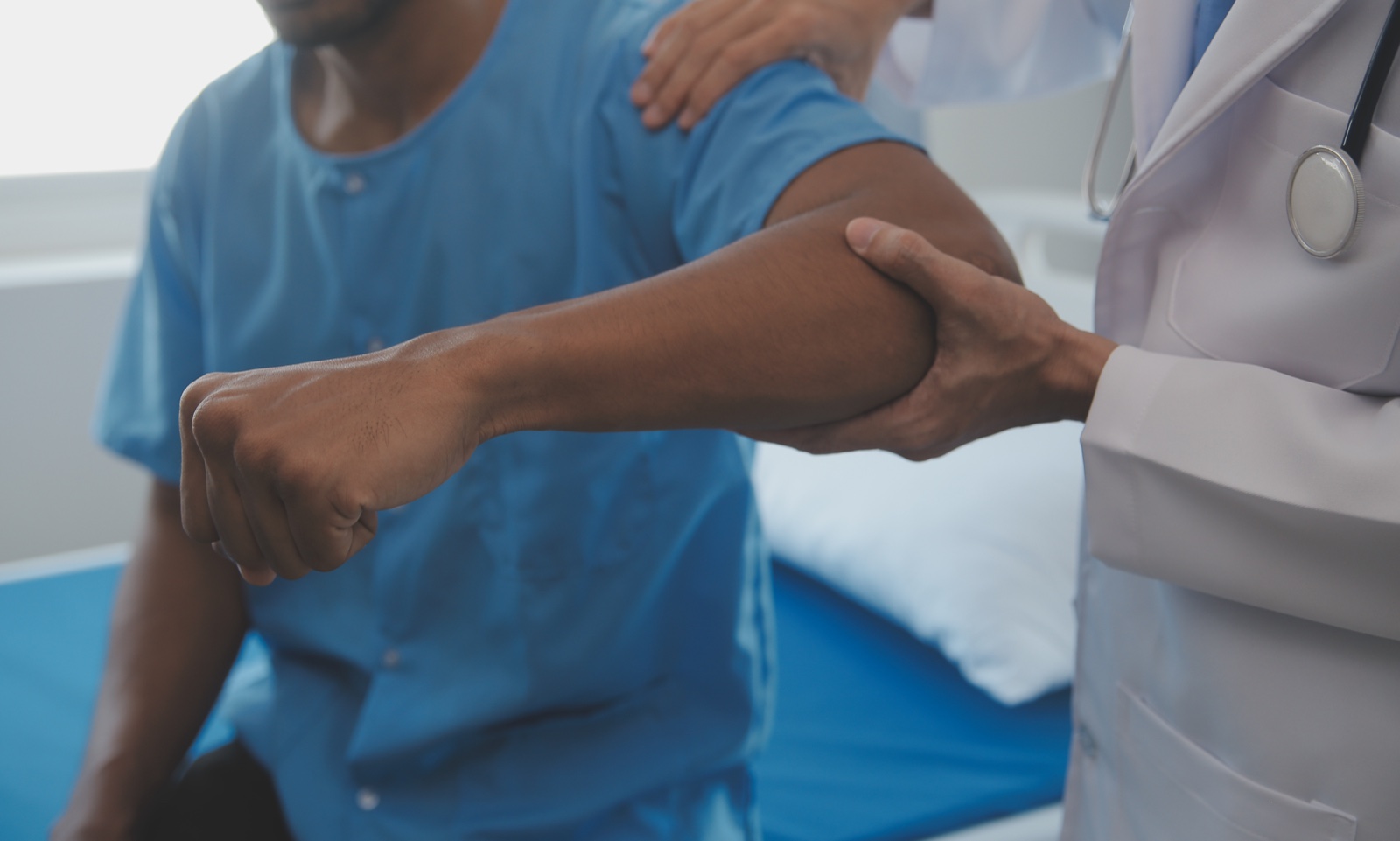 A clinician examining a patient’s elbow joint