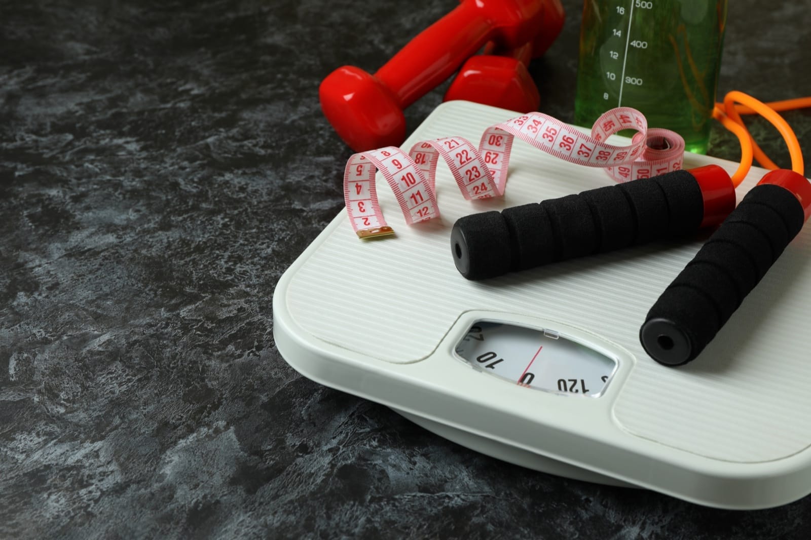 A scale, exercise equipment and measuring tape for weight management